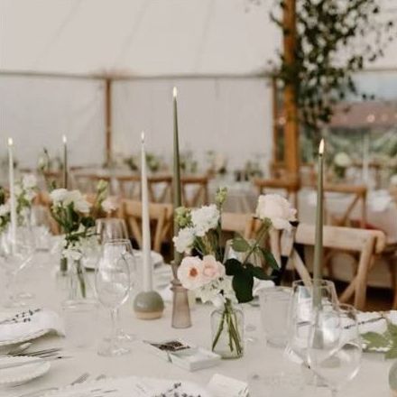 Long dining table styled with delicate botanical bud vases and candles